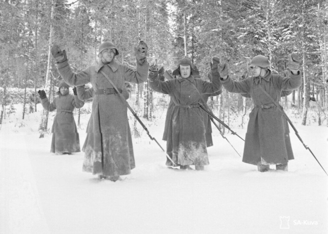 Russian PoWs from the Karvia prisoner of war camp, likely early in the Winter War (i.e., December 1939). Note total lack of winter camo. While the coats look heavy, they’re not waterproofed and totally unsuitable for the Finnish winter conditions. When handed back at the end of the war, Russian PoWs were either executed or sent to labor camps. Photo credit SA-Kuva Russian PoWs from the Karvia prisoner of war camp, likely early in the Winter War (i.e., December 1939). Note total lack of winter camo. While the coats look heavy, they’re not waterproofed and totally unsuitable for the Finnish winter conditions. When handed back at the end of the war, Russian PoWs were either executed or sent to labor camps. Photo credit SA-Kuva