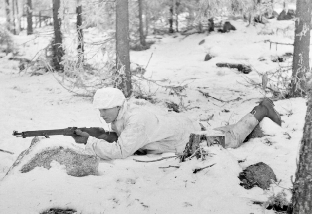 Finnish soldier with a M91/30 rifle, the Finnish version of the Russian-made Mosin-Nagant rifle. Much better than the Russian version, the M91/30 had excellent iron sights graded for 50-meter variations. Note the soldier’s hat cover, which also folded down over the face, completing the camouflage. Photo credit SA-Kuva Finnish soldier with a M91/30 rifle, the Finnish version of the Russian-made Mosin-Nagant rifle. Much better than the Russian version, the M91/30 had excellent iron sights graded for 50-meter variations. Note the soldier’s hat cover, which also folded down over the face, completing the camouflage. Photo credit SA-Kuva