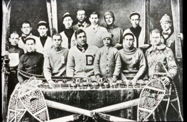 The Dartmouth Outing Club, ca. 1911. Fred Harris, who founded the Club in 1909, is in the center of the photo, wearing the sweater with the “D.” The DOC organized the country’s first downhill and slalom races in the mid- to late 1920s. As the DOC developed, it became the focus of collegiate skiing in America, creating a model that other universities could and did emulate, and connecting the sport to the affluent and elite in the process. Photo credit: New England Ski Museum