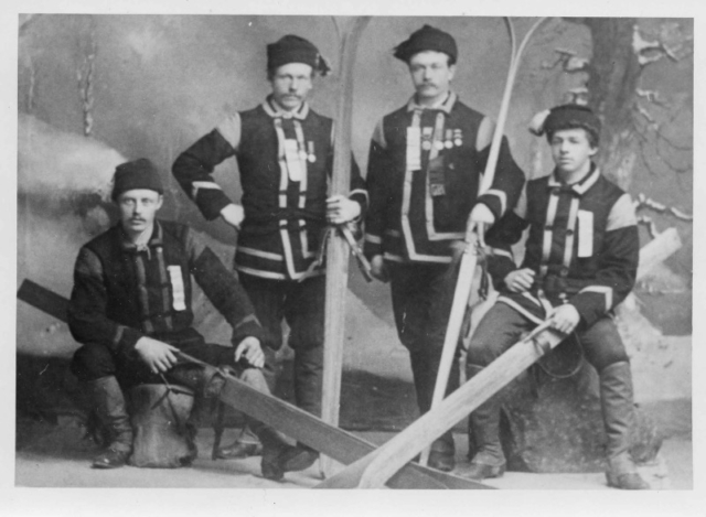 Studio photo, ca. 1900, of Norwegian immigrant skiers in Ishpeming, Michigan, at the National Ski Association, which was founded in 1905. The roots of organized skiing in America are distinctly Norwegian. Organization was key to the creation of modern skiing. It existed to a degree in California, but it was the Norwegian immigrant community that formalized it, promulgating rules and regulations that equalized ski race conditions and that laid the groundwork for professionalism. At the turn of the century, Norwegian was the lingua franca of the pursuit. Photo credit: New England Ski Museum
