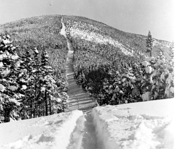 Cannon Mountain’s Taft Trail, which was cut by the Civilian Conservation Corps in 1932-33, was made possible by Depression era funding, cut by CCC. In the early days of downhill racing, turning was considered “sissy.” The first trails, such as this one, were straight and narrow. Photo credit: New England Ski Museum