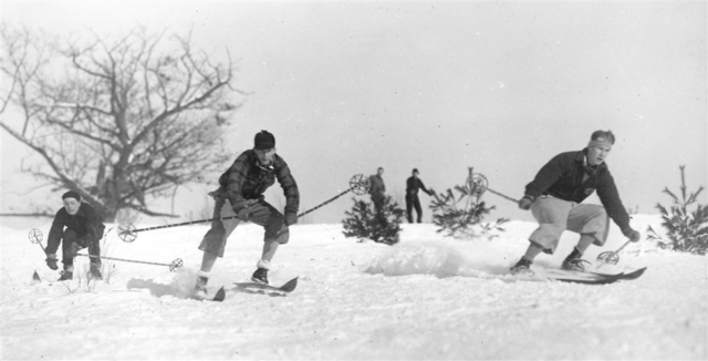 DOC members engaged in the Arlberg Crouch. The Arlberg technique, developed by Hannes Schneider in Austria’s Arlberg mountains in the early 1900s, featured a low crouch and a lift and swing into the turn. By the 1920s, it had begun to spread around the world as “the” technique for skiing. Photo credit: New England Ski Museum